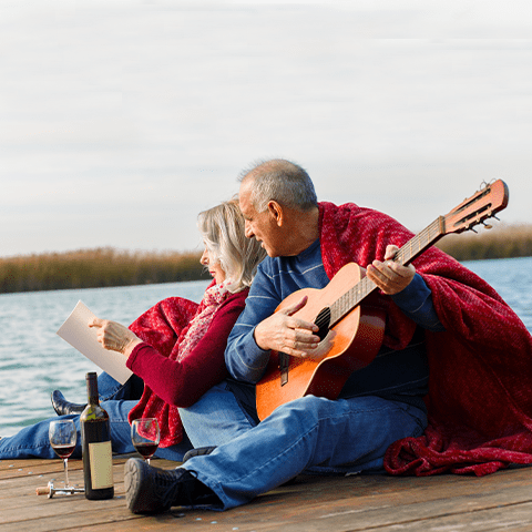 Mature couple with guitar at lake